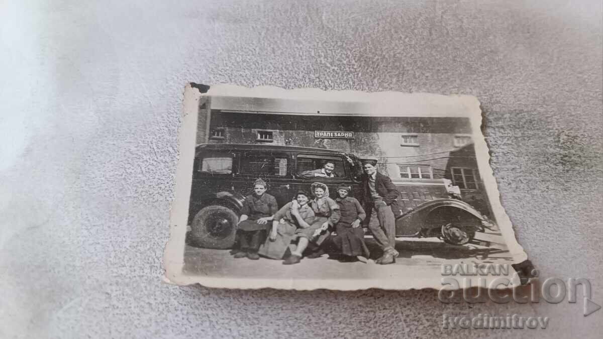 C-ka Tineri și tinere cu mașină retro în fața unei săli de mese