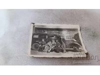 Young men and women with a retro car in front of a dining hall