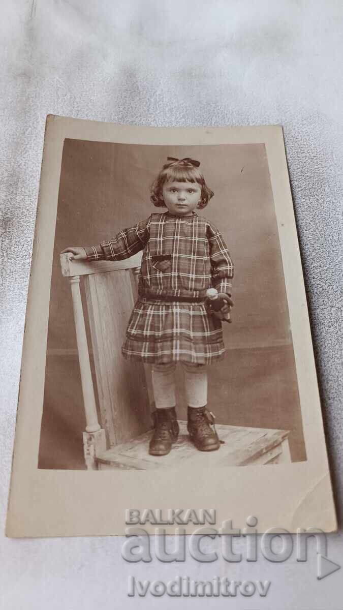 Fotografie Fetiță pe scaun de lemn