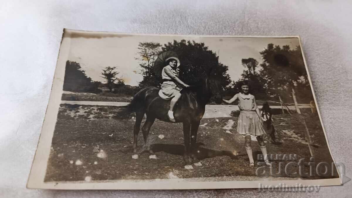 Φωτογραφία Δύο νεαρών κοριτσιών με μαύρο άλογο