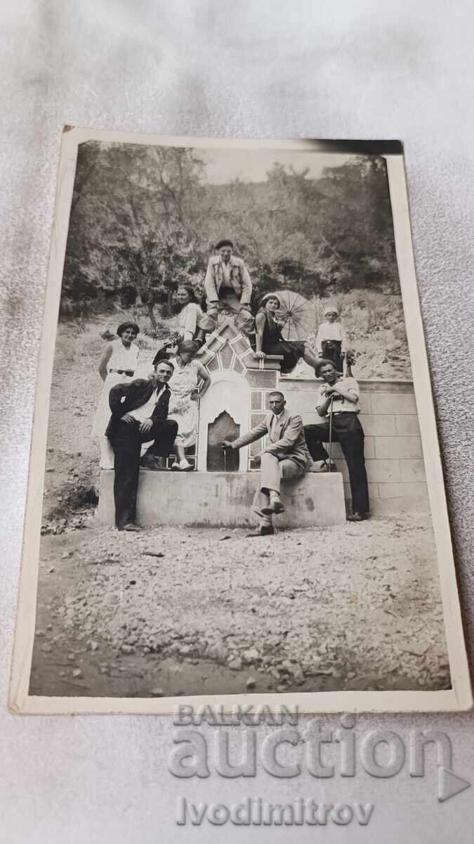 Φωτογραφία Νέων και κοριτσιών γύρω από τη βρύση Φωτογραφία Νέων και κοριτσιών γύρω από τη βρύση