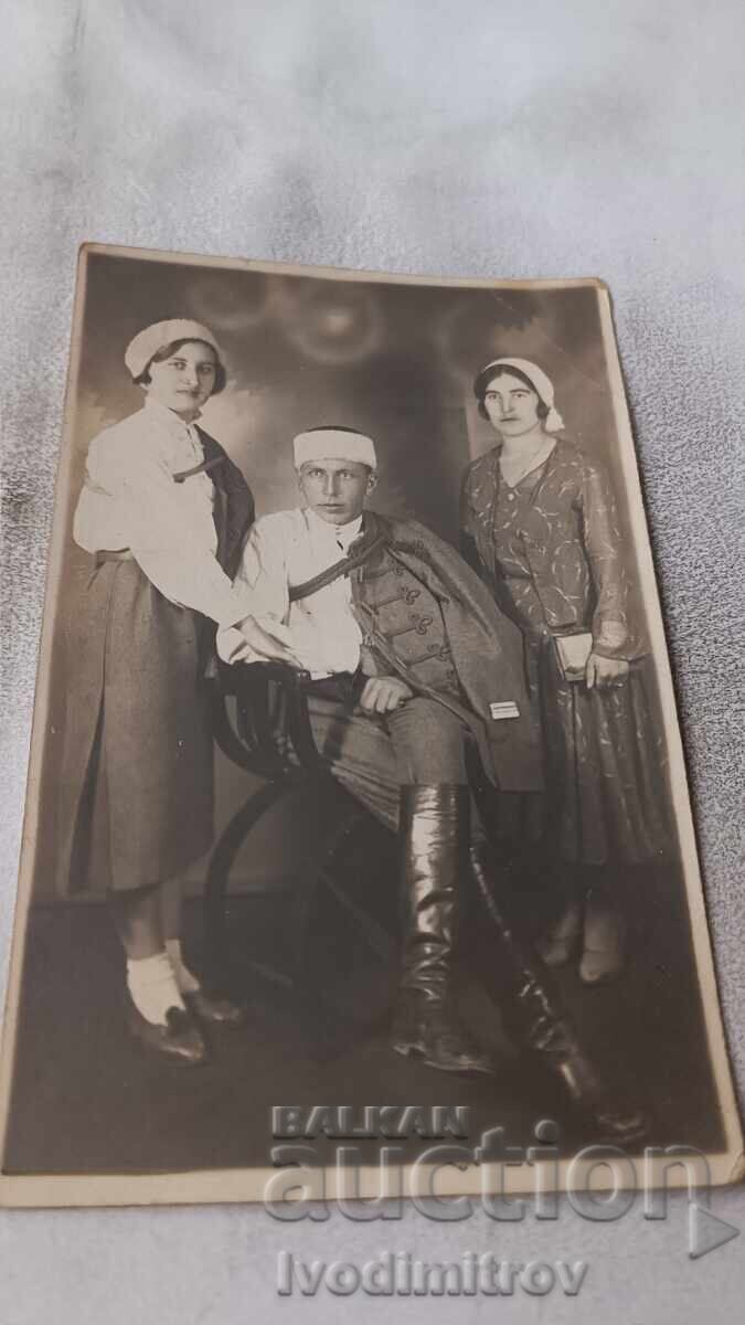 Φωτογραφία Άνδρας και δύο νεαρές γυναίκες σε ηρωικές στολές Φωτογραφία Άνδρας και δύο νεαρές γυναίκες σε ηρωικές στολές