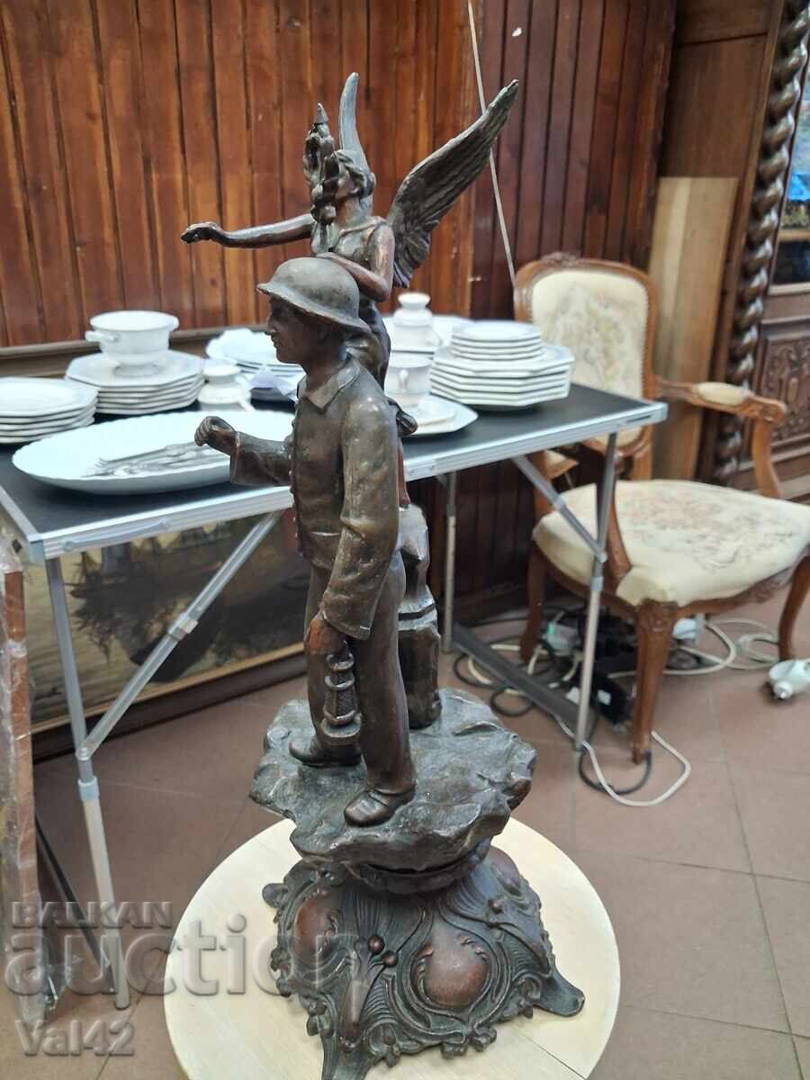 Licitație Sculptură figurativă metalică – Bărbat cu lanternă și figură cu aripi