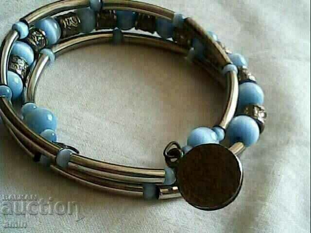 Old bracelet made of natural stone with a coin