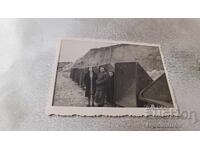 Φωτογραφία Άνδρας και δύο γυναίκες μπροστά από καμπίνες στην παραλία