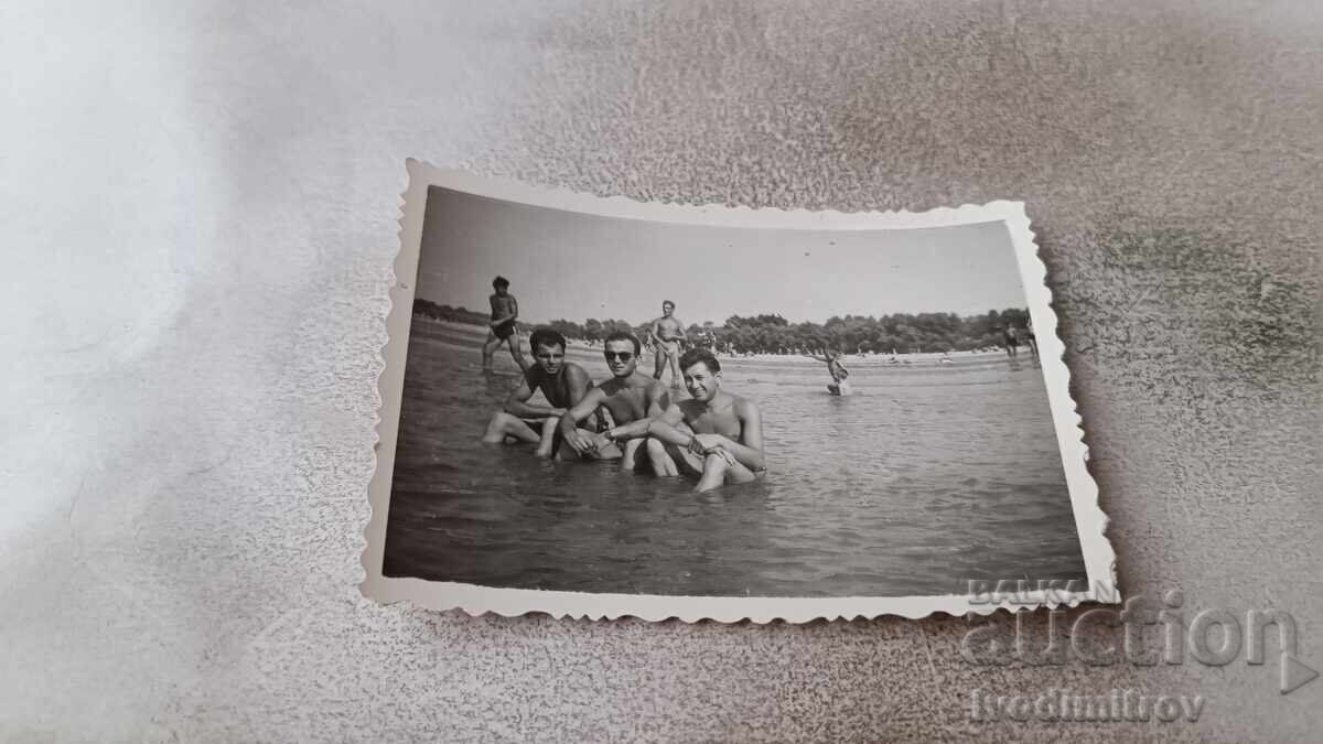 Foto Trei tineri pe plajă