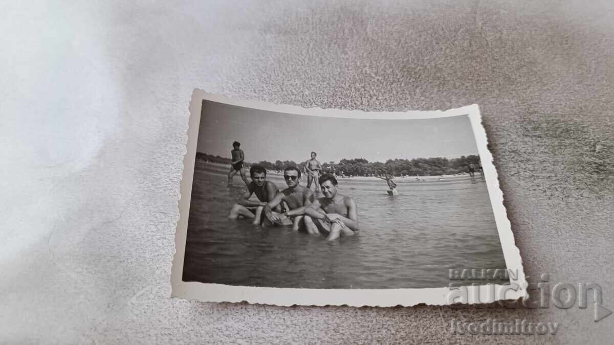 Φωτογραφία Τρεις νεαροί άνδρες στην παραλία