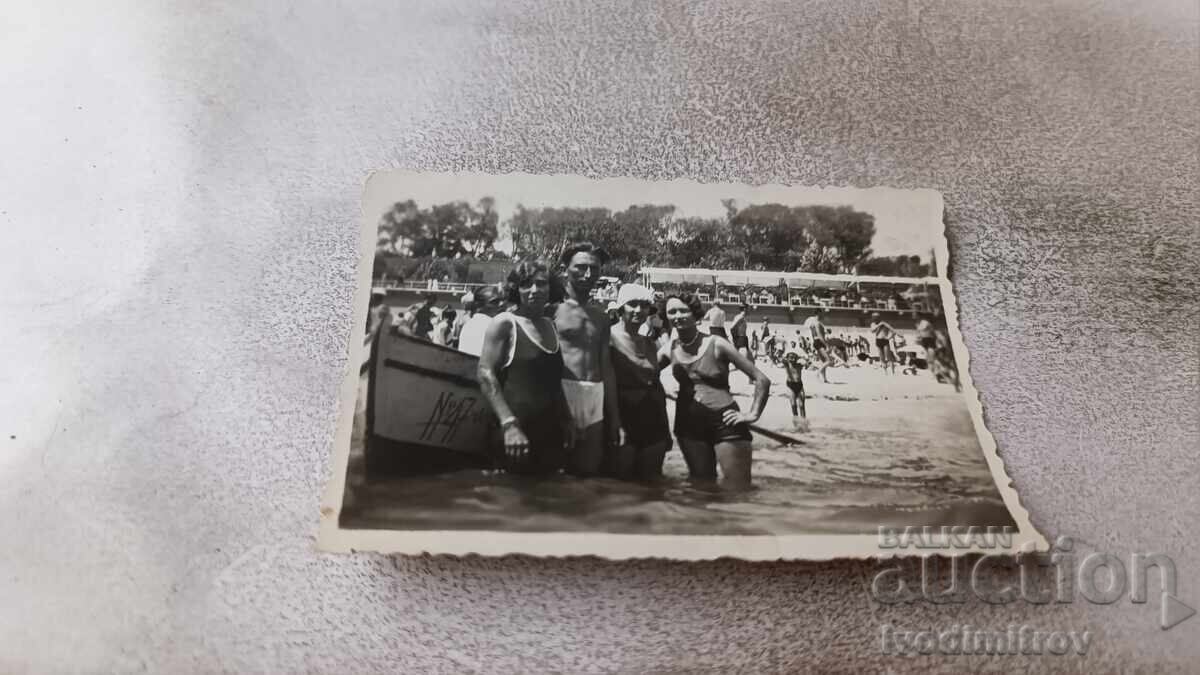 Снимка Мъж и три млади момичета с ретро бански в морето Снимка Мъж и три млади момичета с ретро бански в морето