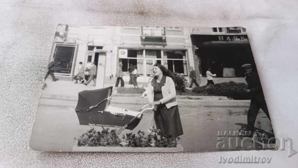 Photo of a Young Woman with a Stroller on the Street