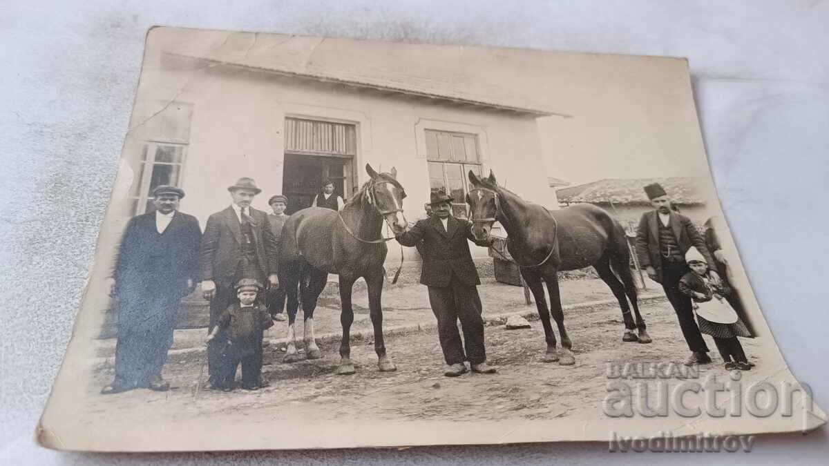 Photo of Men and Children with Two Black Horses