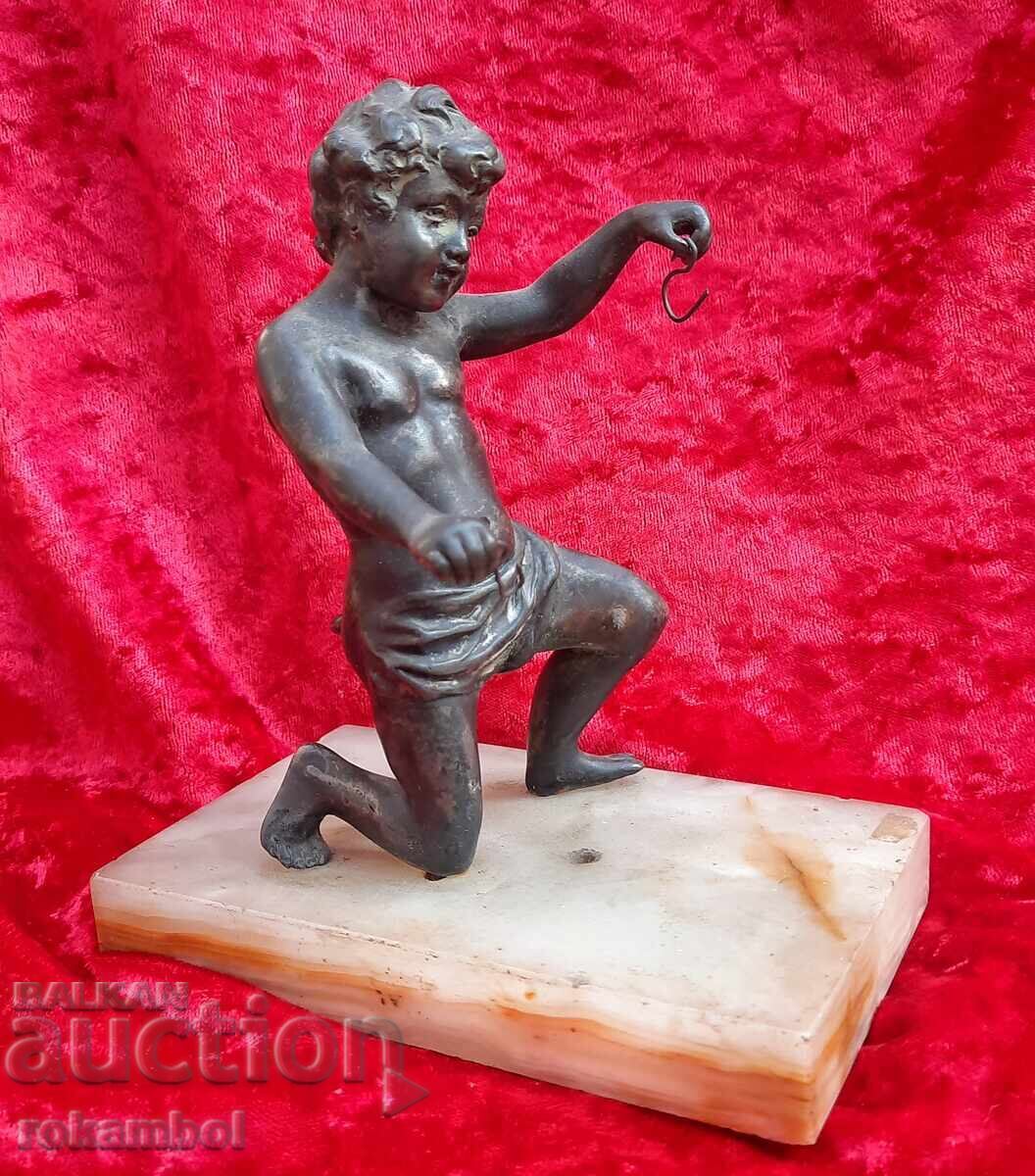 Старинна метална фигурка върху мрамор