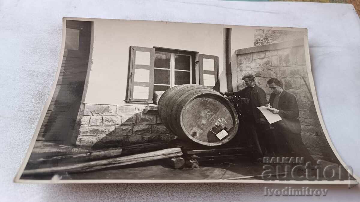 Снимка Двама мъже до бъчва за вино във винарска изба