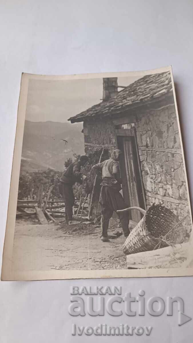 Photo of Two Men in Front of an Old Village House Photo of Two Men in Front of an Old Village House