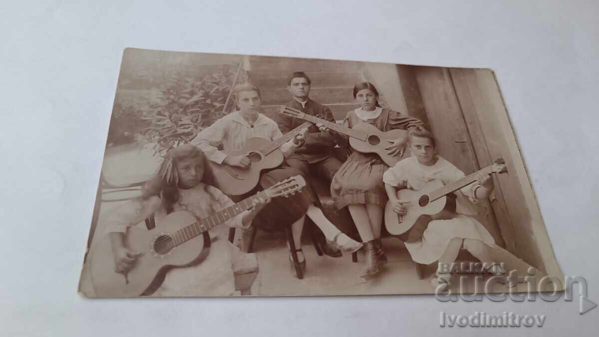 Fotografie Tânăr și patru fete cu chitare Fotografie Tânăr și patru fete cu chitare