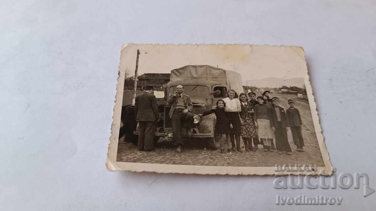 Снимка Мъже жена момчета и момичета пред ретро камион
