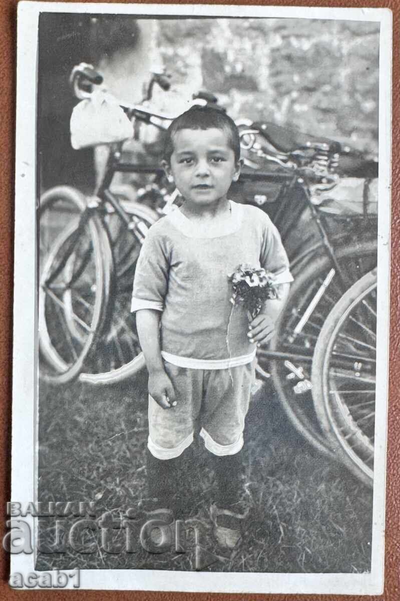 Copil cu buchet în fața roților Copil cu buchet în fața roților