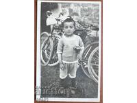 Copil cu buchet în fața roților