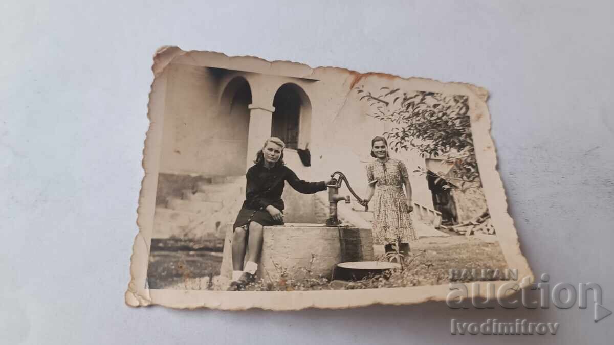 Снимка Жена и момиче до ръчна помпа за вода Снимка Жена и момиче до ръчна помпа за вода