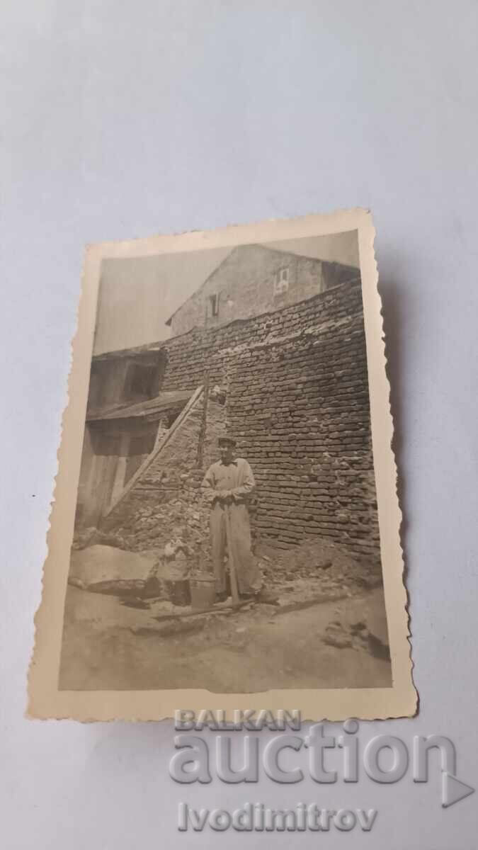 Φωτογραφία Άνδρας με αξίνα μπροστά από παλιό σπίτι 1940 Φωτογραφία Άνδρας με αξίνα μπροστά από παλιό σπίτι 1940