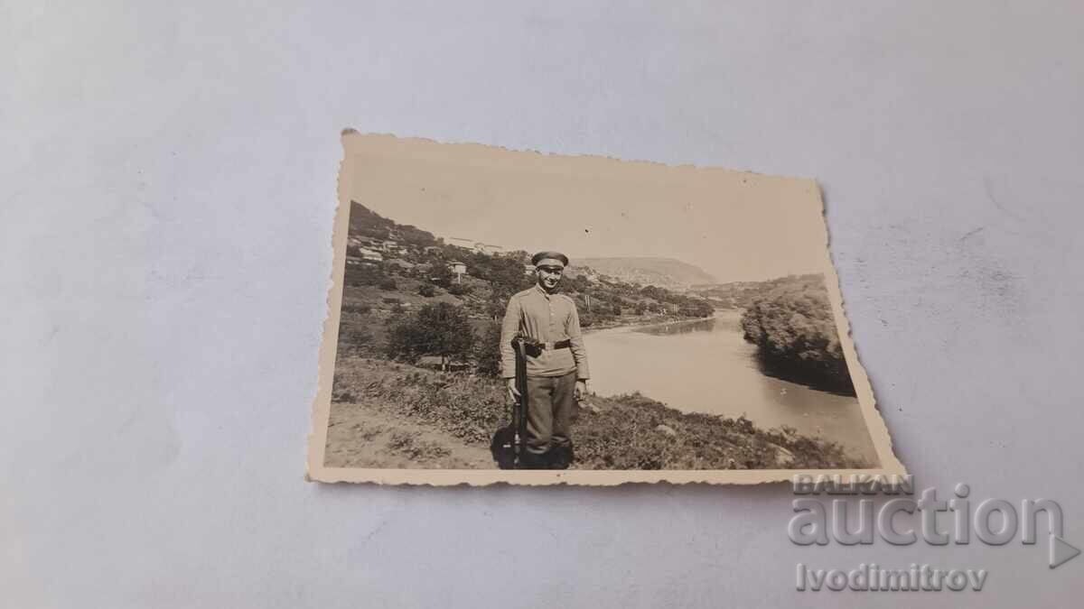 Fotografie Soldat cu pușcă lângă râu 1940 Fotografie Soldat cu pușcă lângă râu 1940