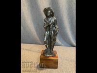 стара калаена статуя на човек с шапка върху дървена основа