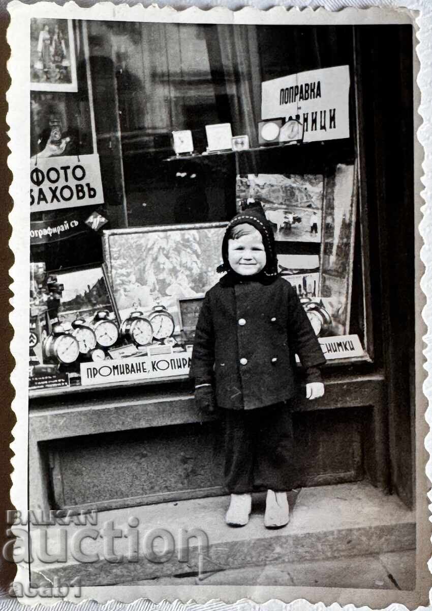 Παιδί μπροστά από Στούντιο Φωτογραφίας και Ωρολογοποιείο