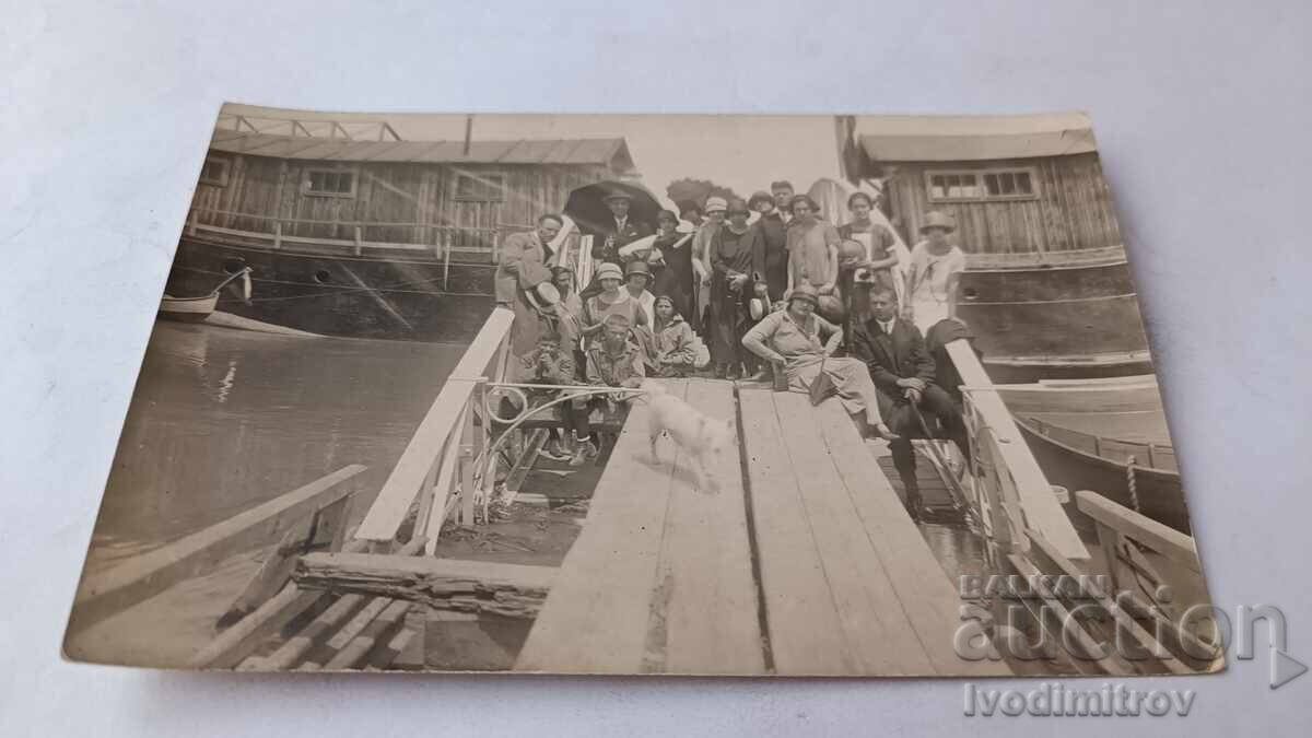 Fotografii Tineri și tinere cu cățeluș alb pe ponton de lemn