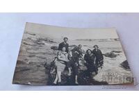Photo of Nessebar: Men and young women on rocks in the sea