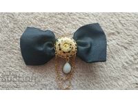 Old lady's stylish bow tie, brooch