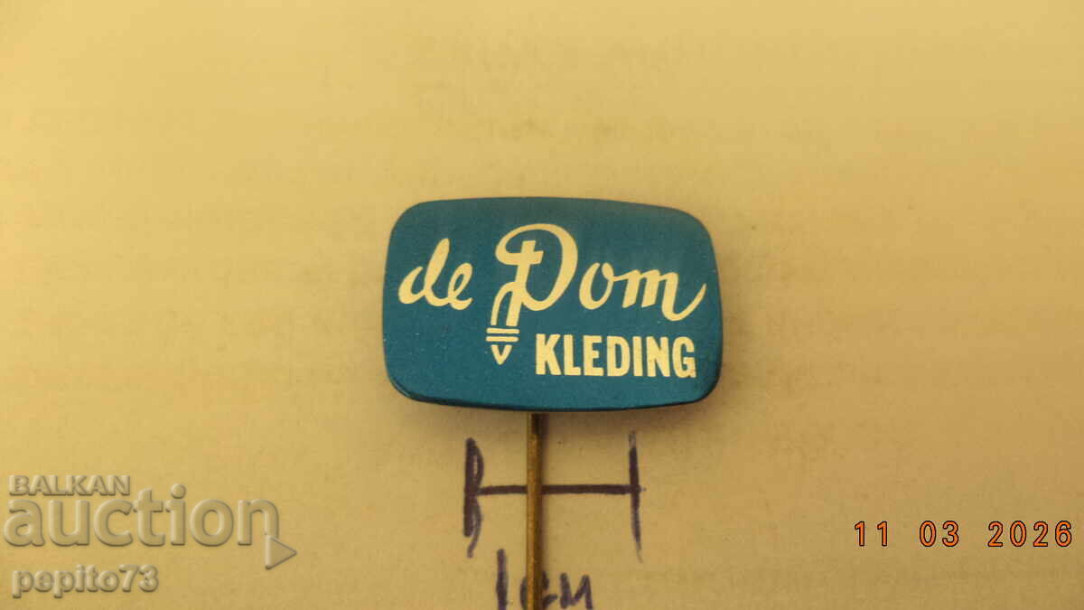 Insignă publicitară, de Dom Kleding, marcă de îmbrăcăminte