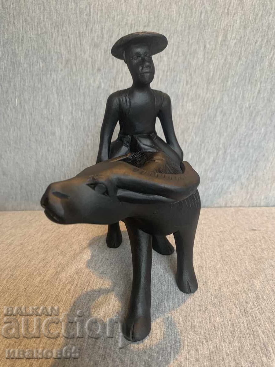 дървена фигурка на азиатски мъж, яздещ бивол с цена € 25.00 | 48.90 лв.