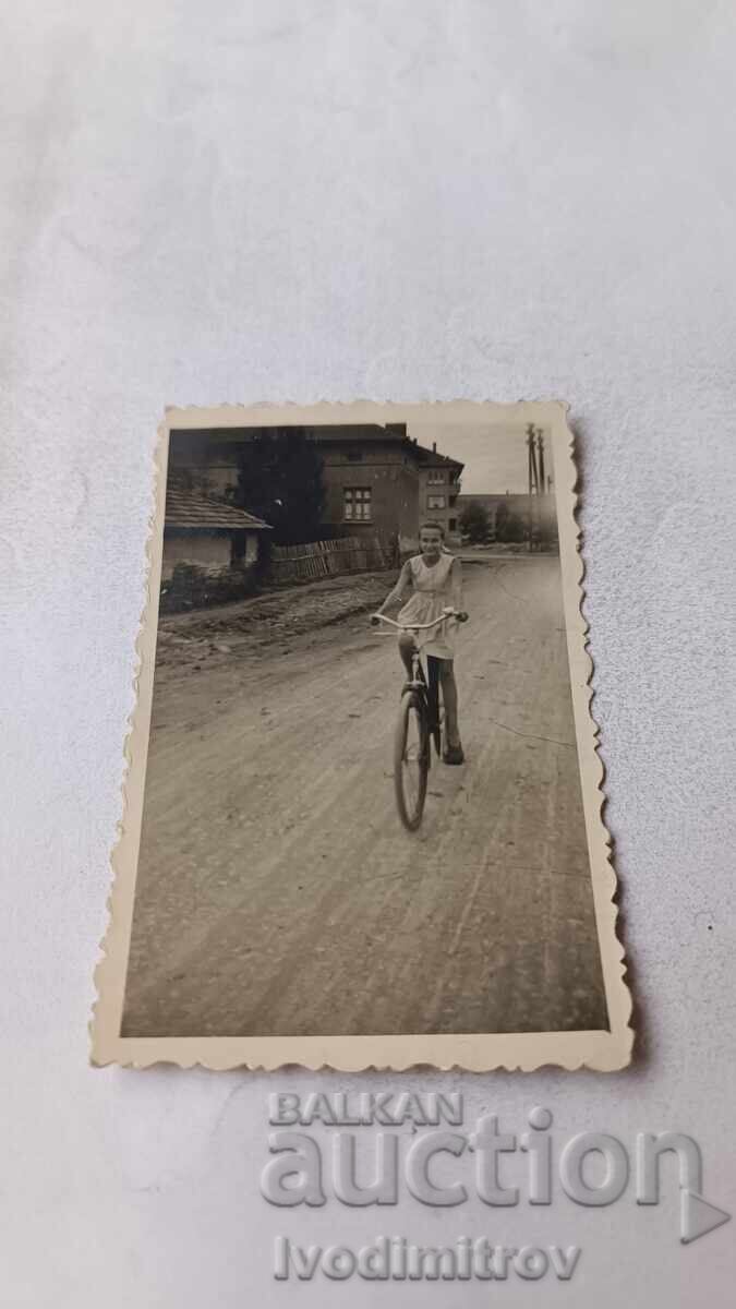Poza Fată cu bicicletă roșie pe șosea