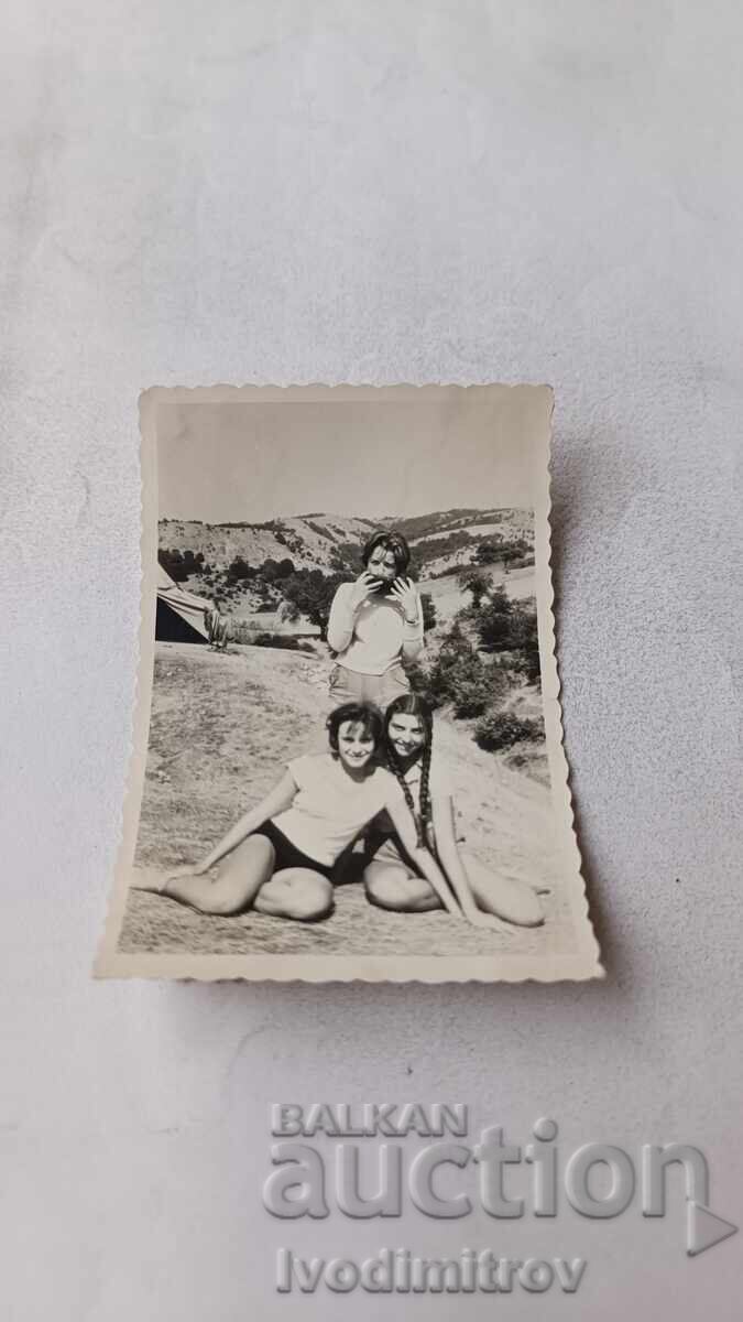 Poză Trei fete tinere în fața unui cort în munți