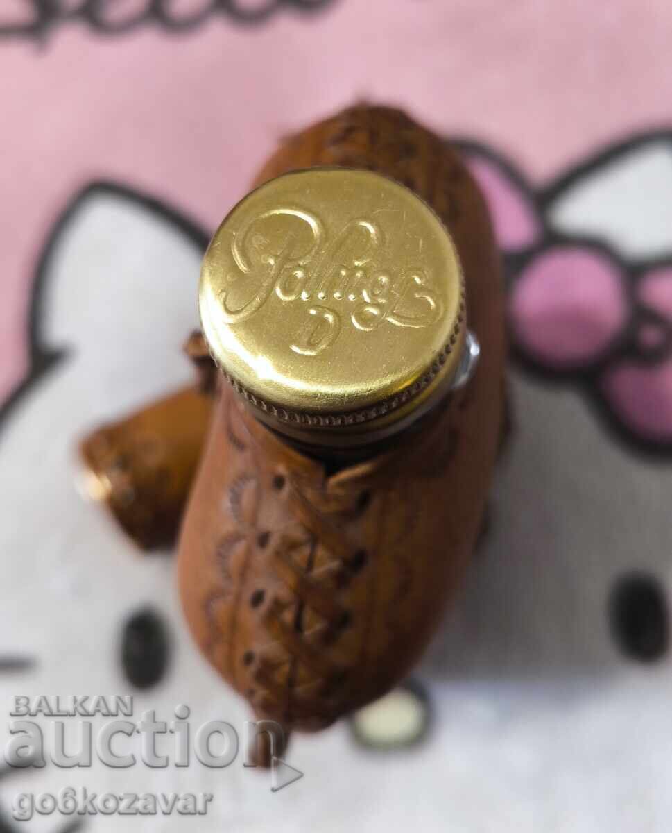 Доставка на Винтидж бутилка, покрита с кожа и метални нитове