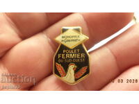 Insignă Monoprix, lanț francez de supermarketuri