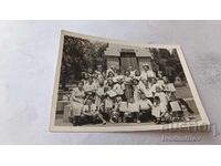 Fotografie Copii cu învățătoarele lor în fața unui monument