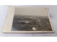 Снимка Трима мъже гегнали на тревата над града