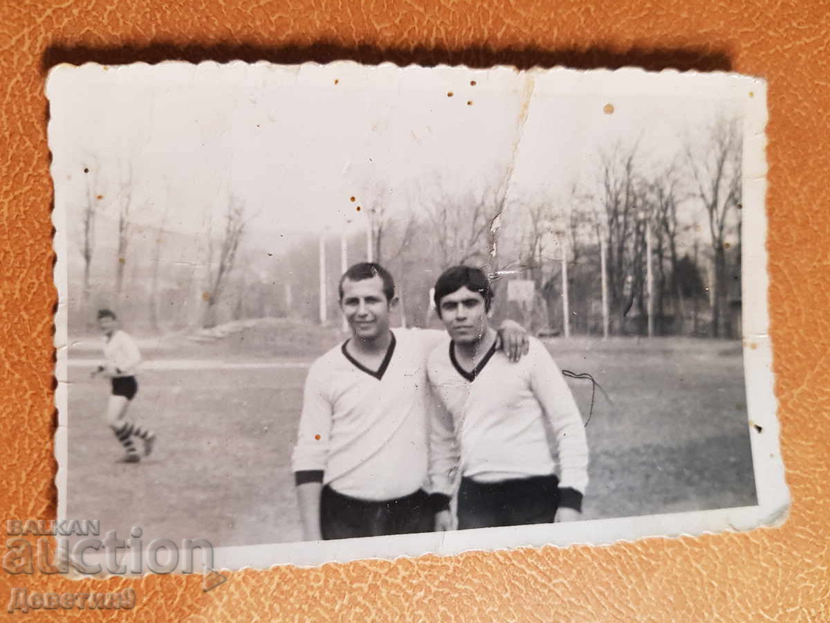 Doi fotbaliști pe un stadion de sat