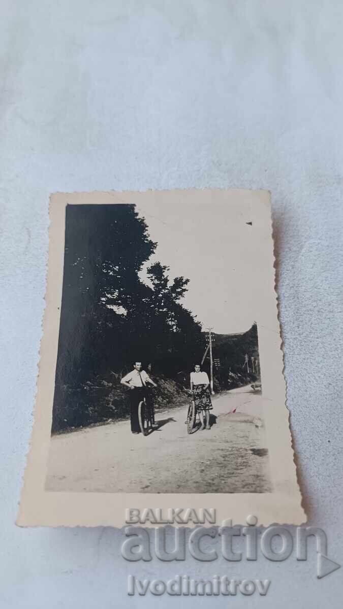 Φωτογραφία Νέος και κοπέλα με ρετρό ποδήλατα στον δρόμο