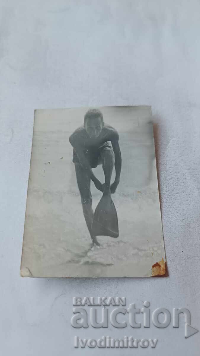 Φωτογραφία άνδρα με βατραχοπέδιλα στην ακροθαλασσιά