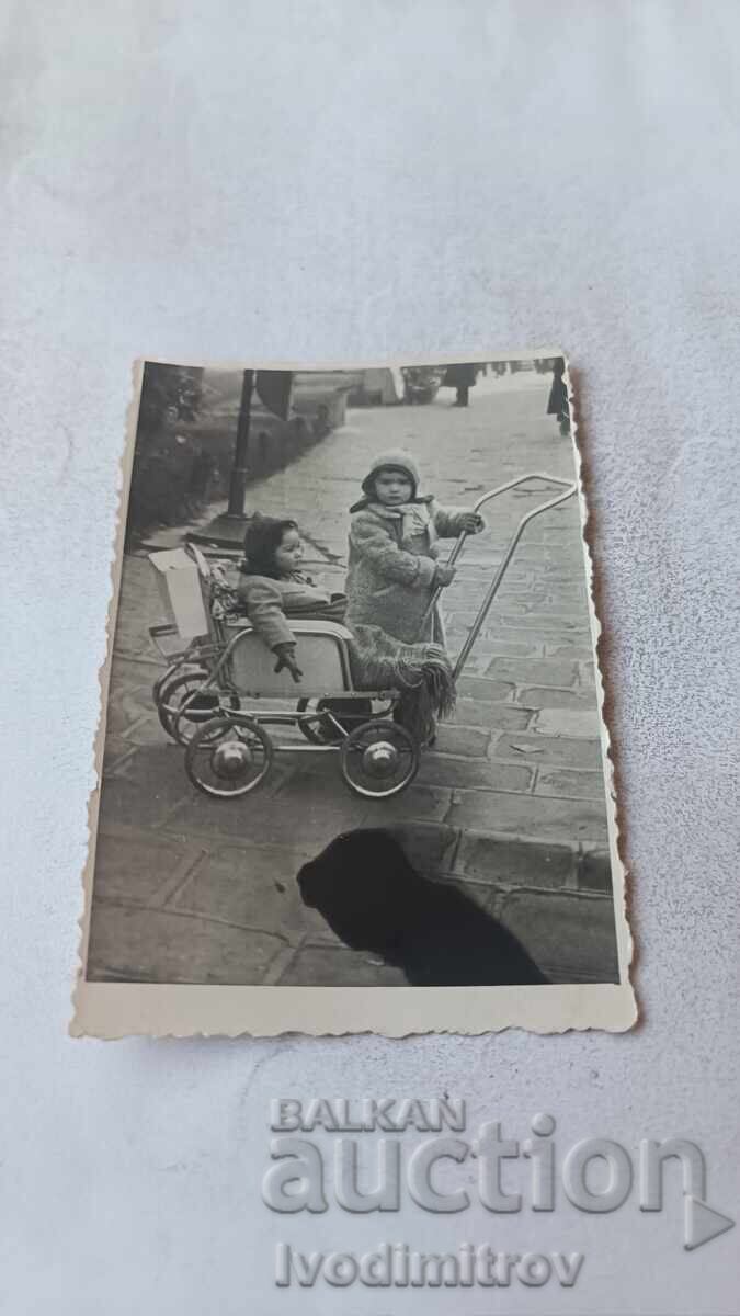 Φωτογραφία Σόφια Δύο παιδιά με ρετρό παιδικό καρότσι στο πεζοδρόμιο