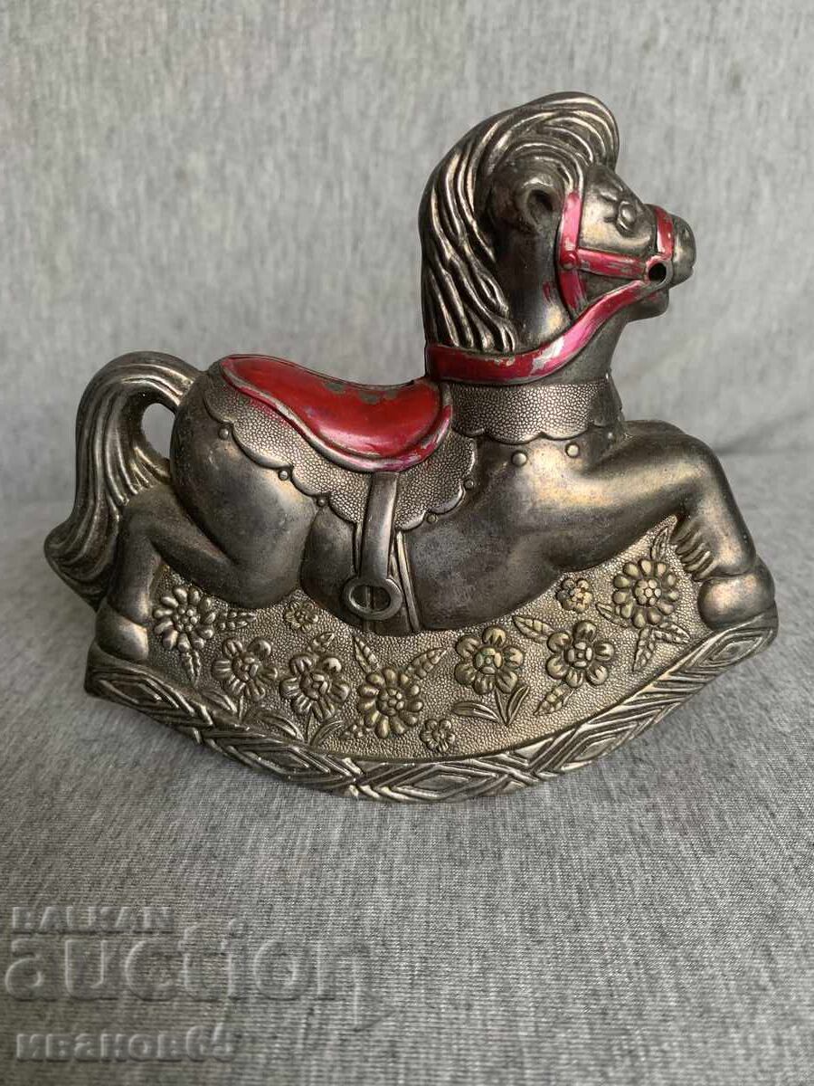 Coin bank in the shape of a rocking horse