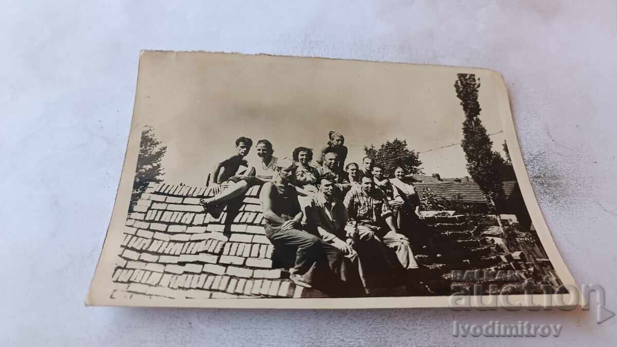 Photo: Young men and women on a pile of single bricks