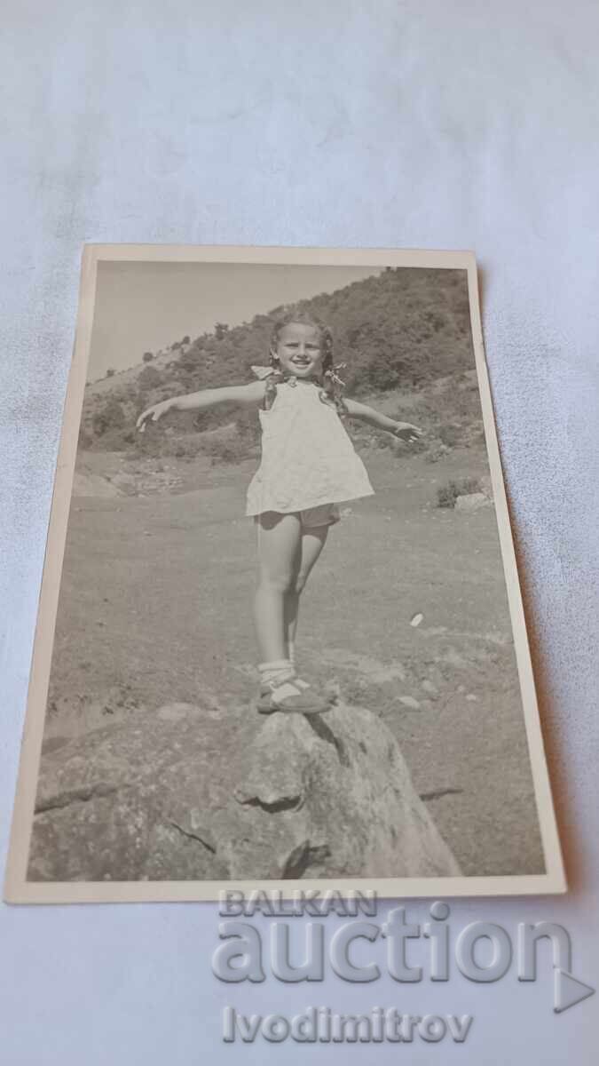 Fotografie Fetiță urcată pe o piatră mare