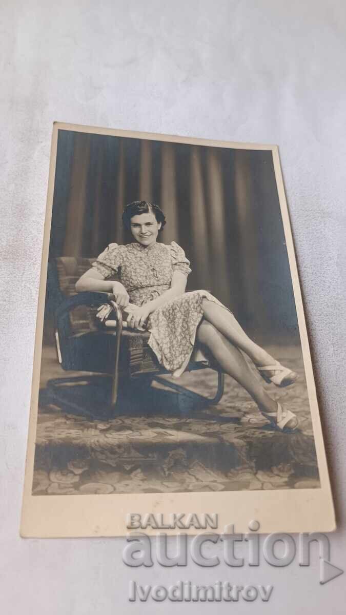 Fotografie Tânără femeie așezată pe un fotoliu