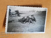 Trei soldați la exercițiu cu o mitralieră