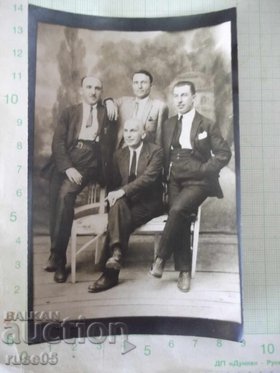Снимка на четирима мъже на пейка във фотостудио стара