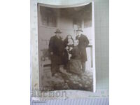 Φωτογραφία δύο ανδρών και δύο γυναικών με ένα παιδί μπροστά από ένα παλιό σπίτι