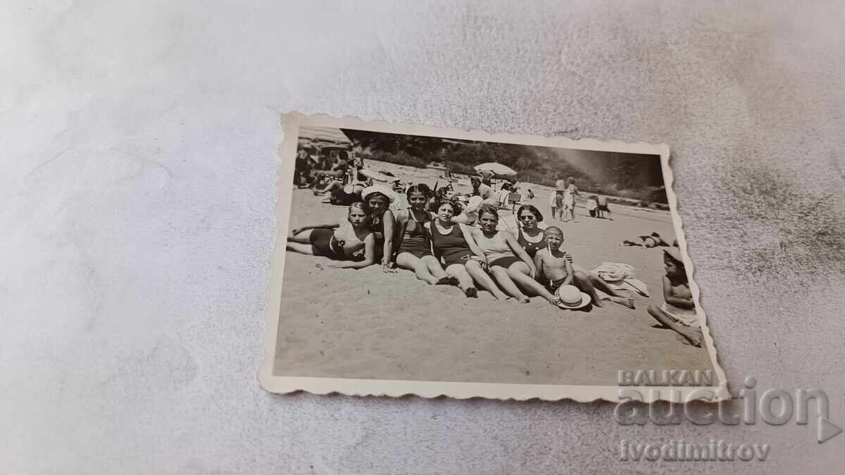 Fotografie băiat și fete pe plajă