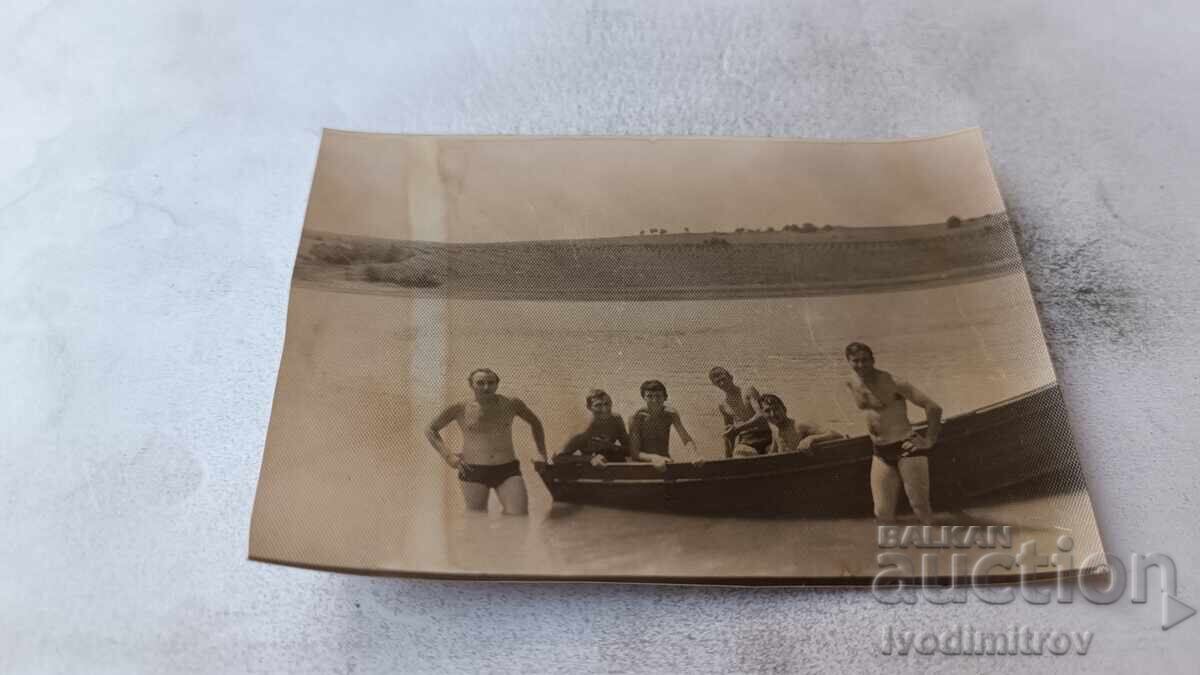Fotografie Bărbați și băieți cu o barcă pe mare